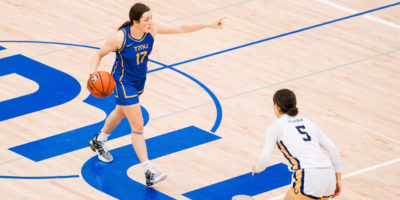 TMU Bold women's basketball player Catrina Garvey dribbles the ball up the court while giving direction