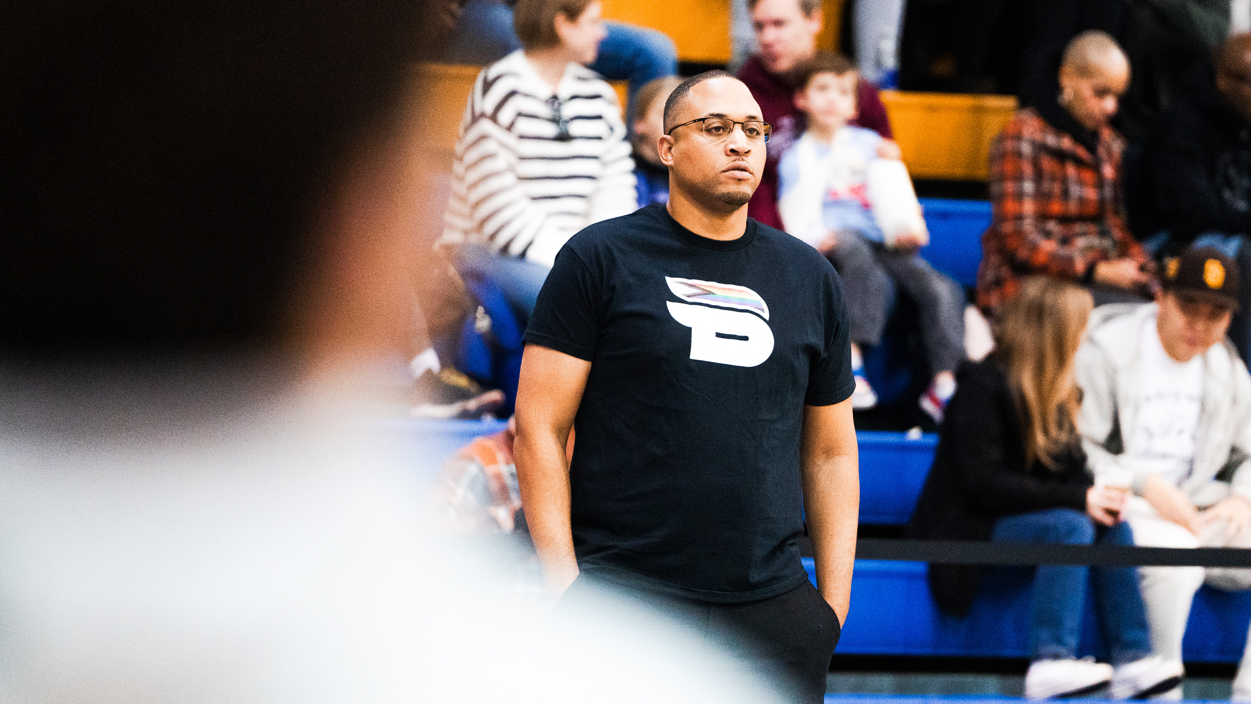 TMU men's basketball assistant coach Jeremie Kayeye stands while wearing the Bold Pride shirt