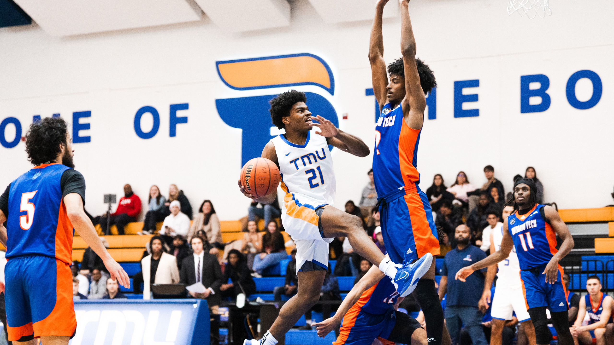 TMU men's basketball player Gabe Gutsmore goes up for a layup against an Ontario Tech defender