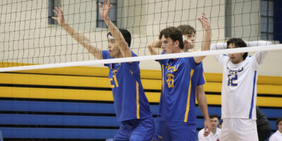 Players from the TMU men's volleyball team prepare to block a serve from the Windsor Lancers