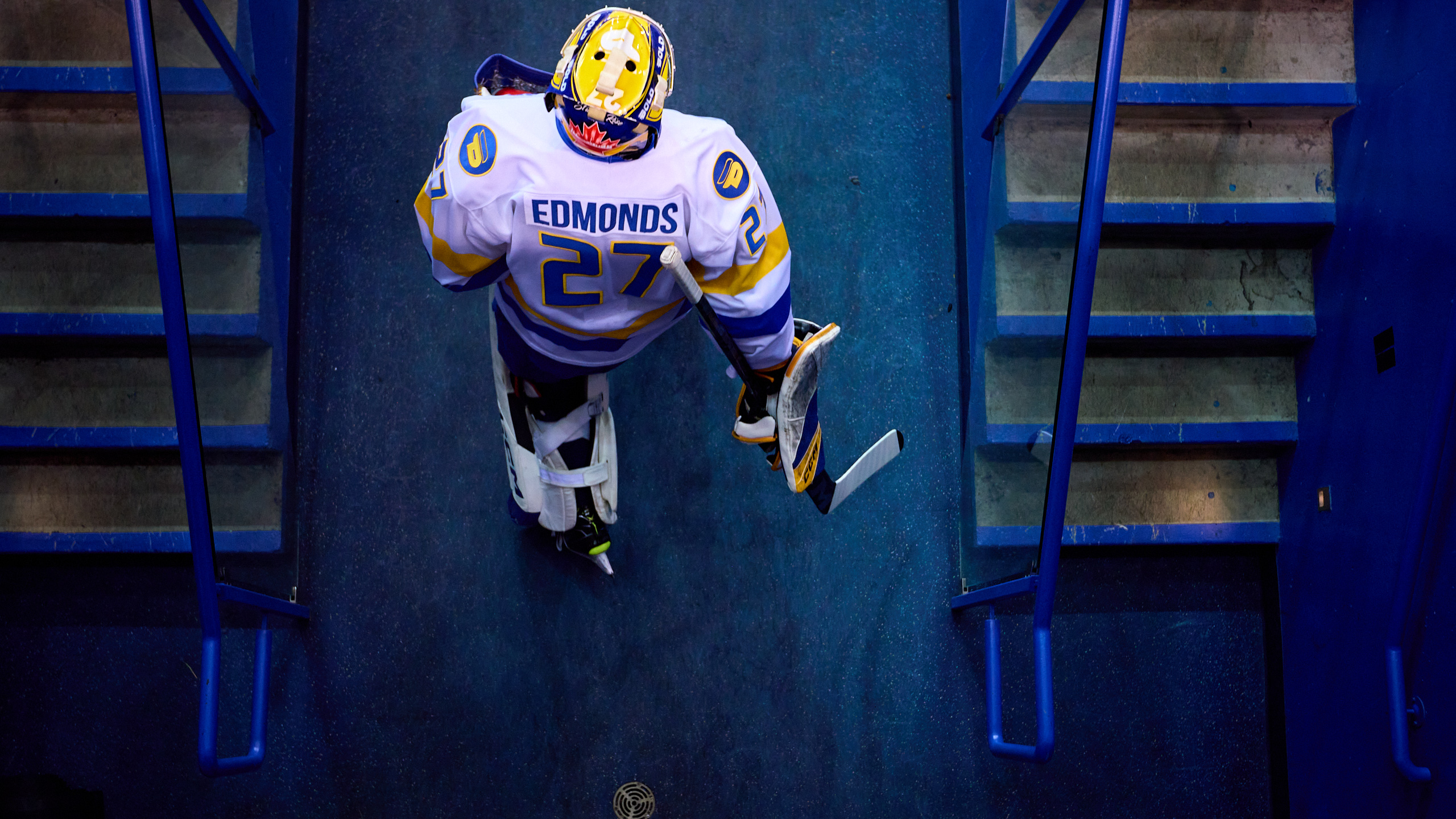 TMU men's hockey goaltender Kai Edmonds walks out of the locker room tunnel towards the ice