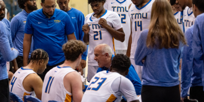 TMU Bold men's basketball head coach Dave DeAveiro yells at his team during a timeout huddle