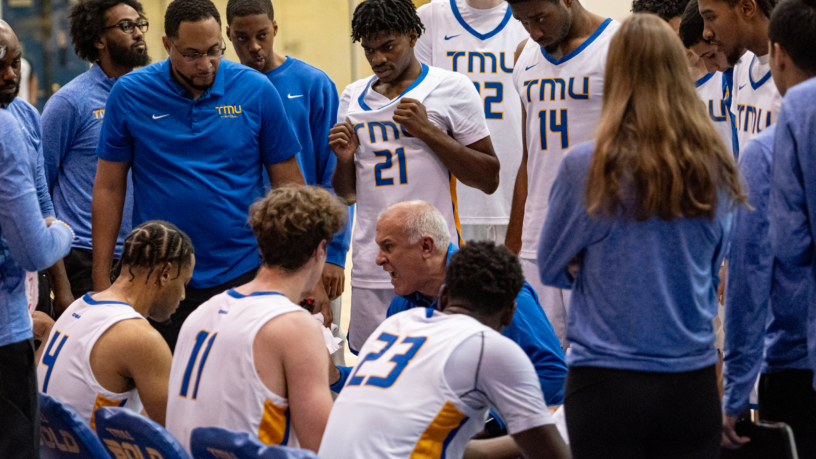 TMU Bold men's basketball head coach Dave DeAveiro yells at his team during a timeout huddle