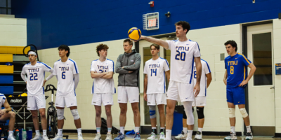 TMU Bold men's volleyball player Alex King sets up to serve a volleyball
