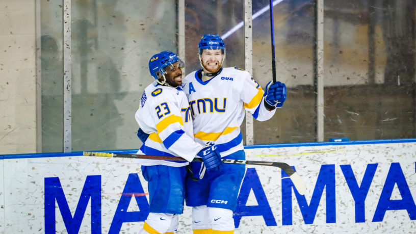 TMU men's hockey player Connor Bowie celebrates scoring a goal with teammate Elijah Roberts
