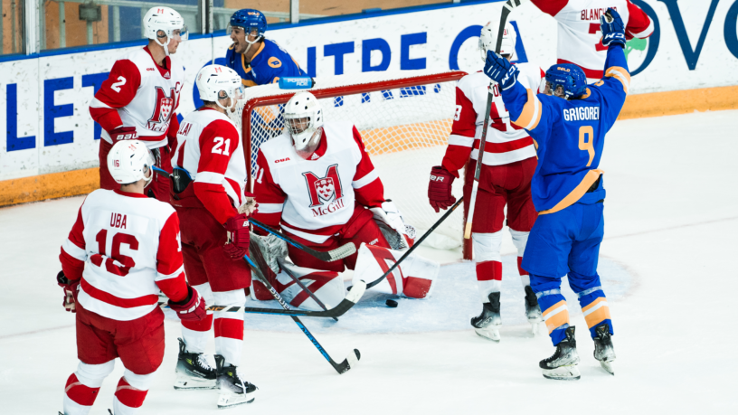 TMU Bold men's hockey player Daniil Grigorev celebrates in front of the McGill Redbirds net