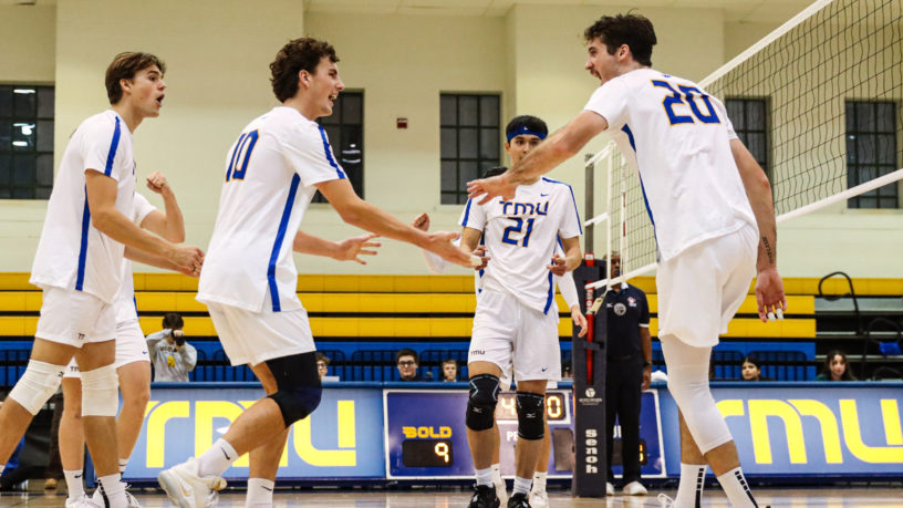 Players from the TMU men's volleyball team celebrate after scoring a point