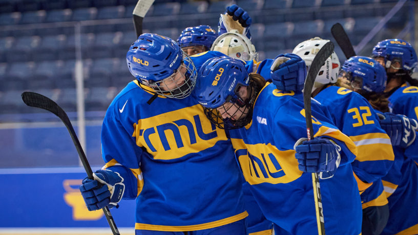 TMU Bold women's hockey players Gaby Gareau and Ahalya Julien-Medeiros hug on the ice