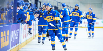 The TMU Bold men's hockey team gives high fives to Daniil Grigorev