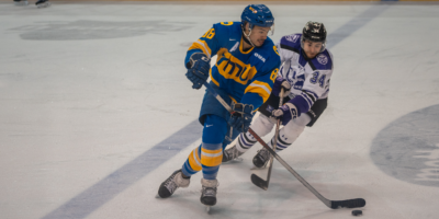 TMU Bold men's hockey player Kyle Bollers faces against a Western Mustangs player