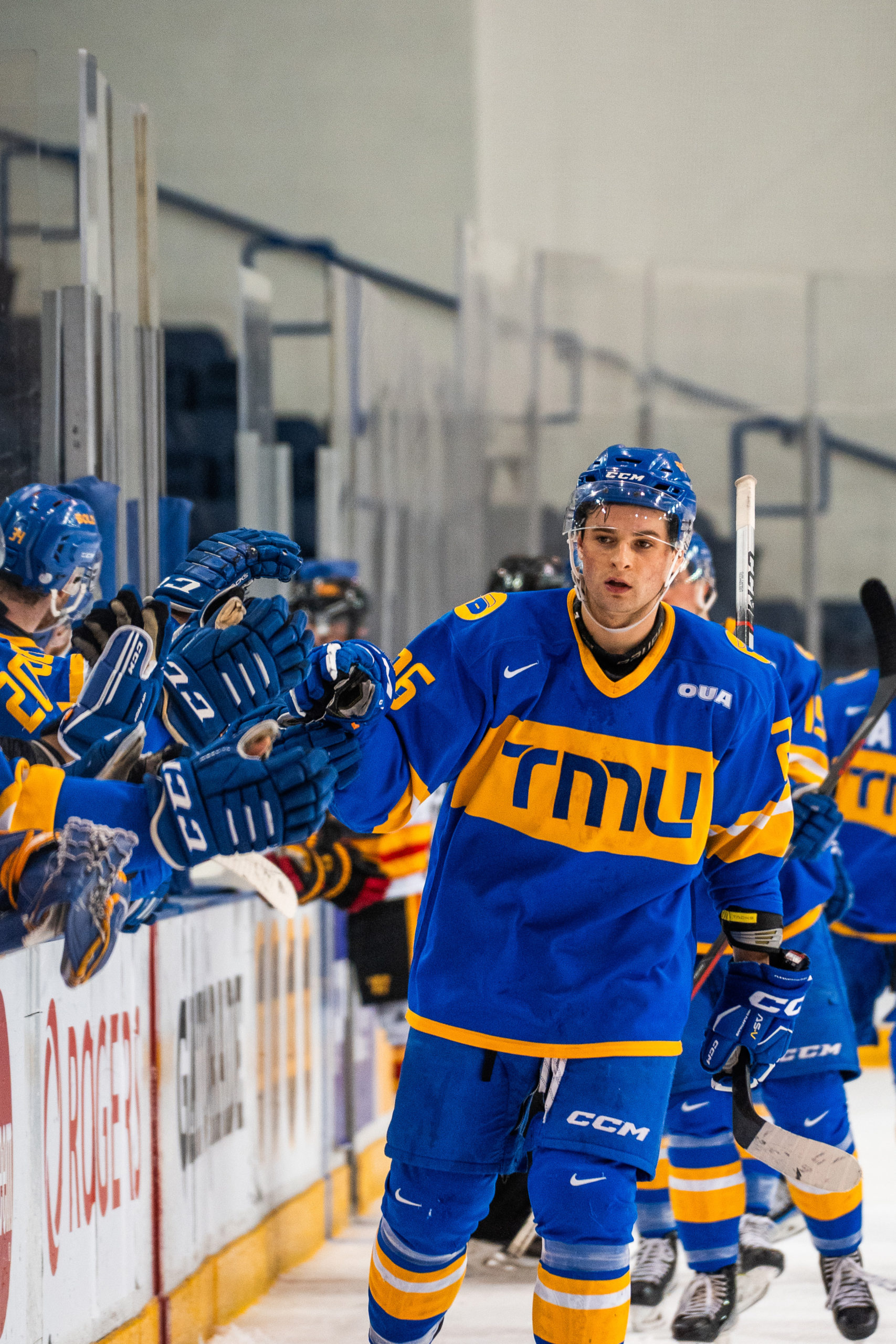 TMU men's hockey player Ian Martin fistbumps his teammates after a scoring a goal