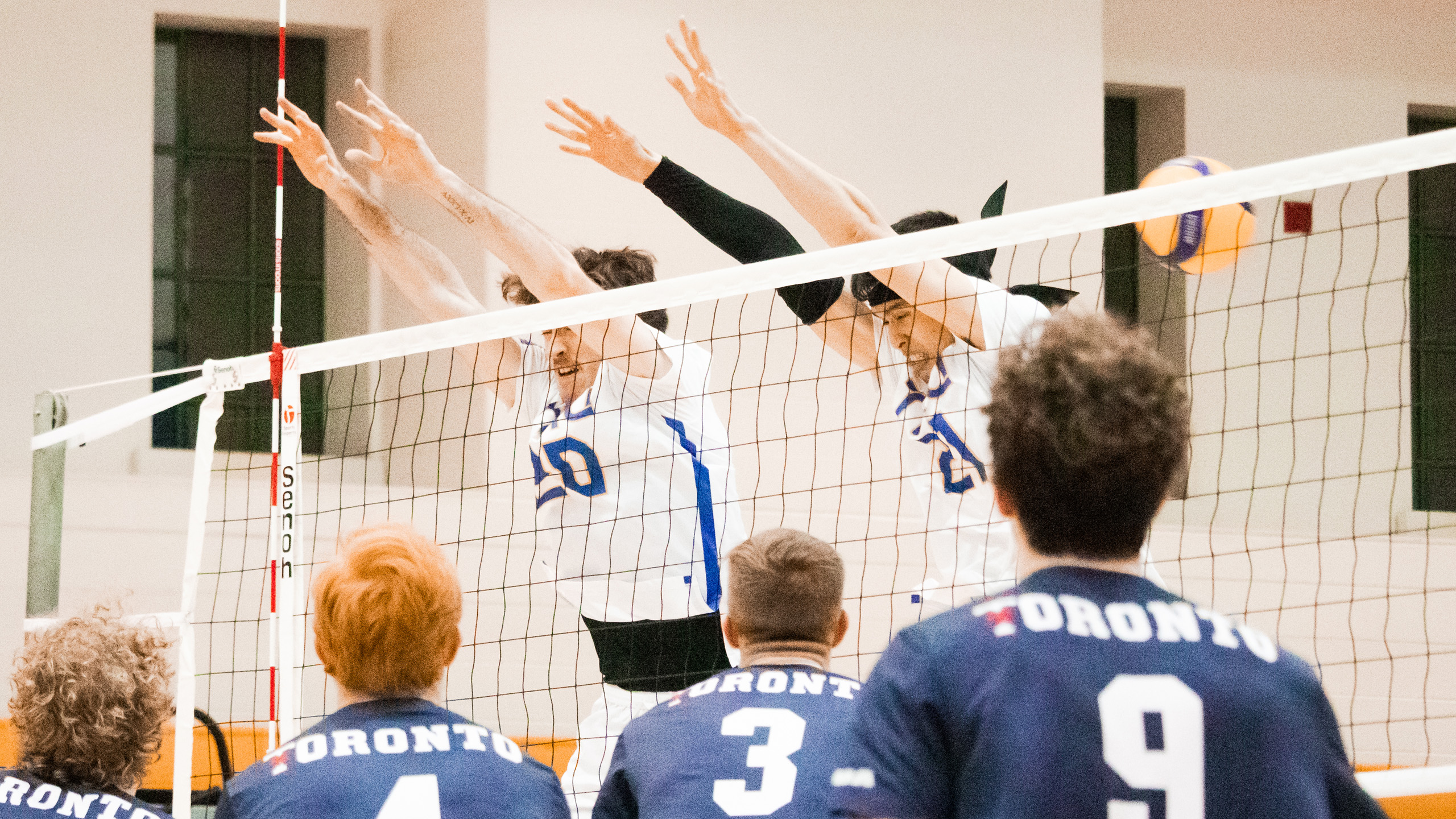 TMU men's volleyball players Alex King and Bobby Tang attempt to block a U of T spike