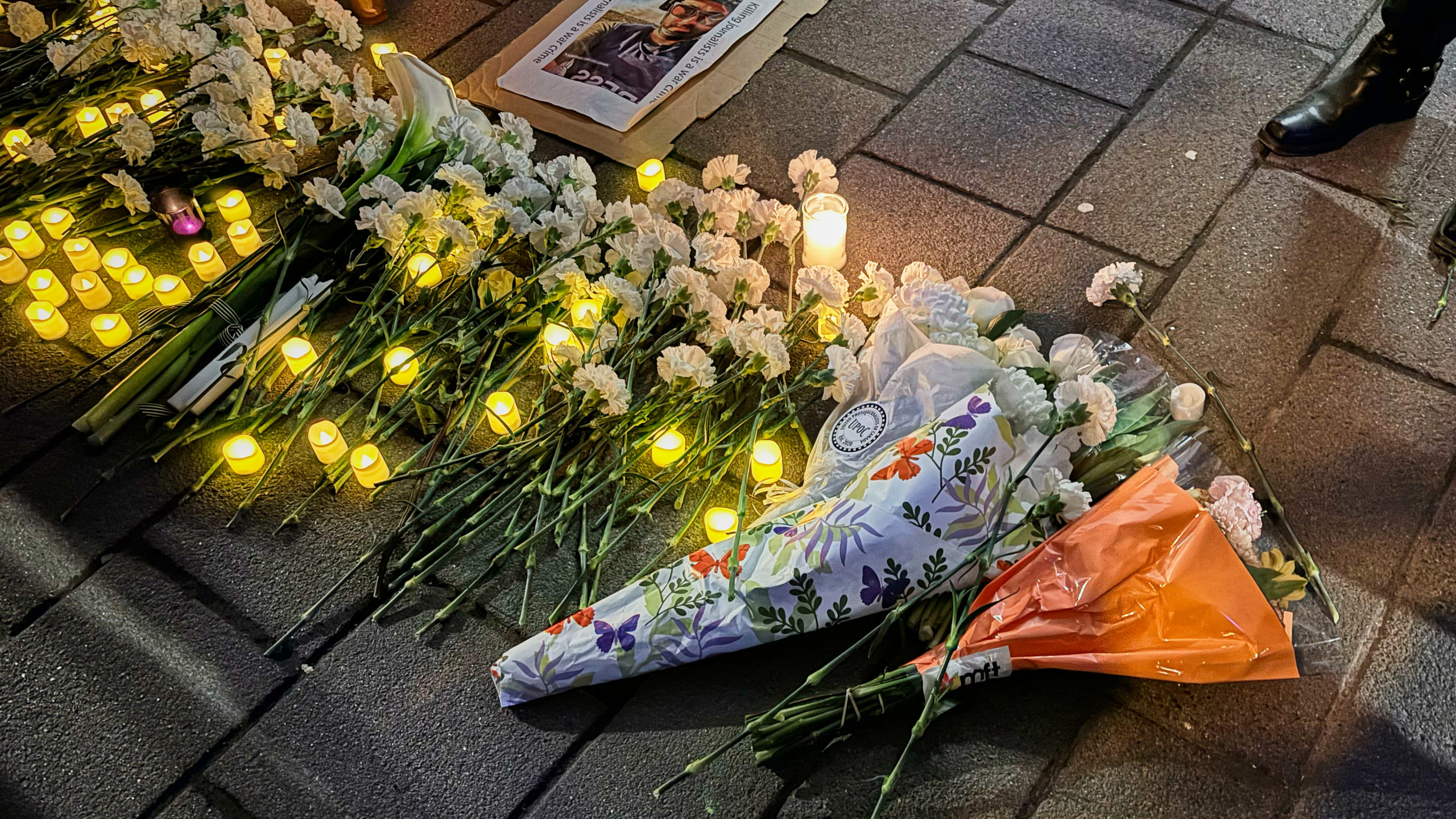 flowers lay on the ground at a vigil