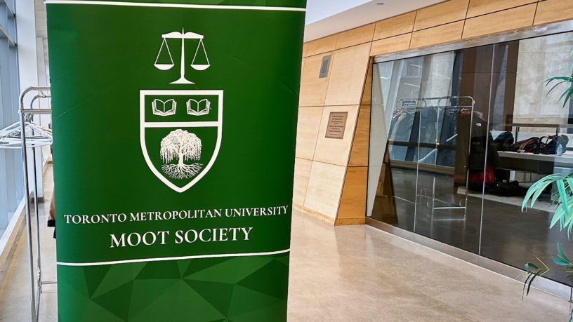 The TMU MOOT society sign in a hallways