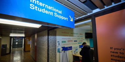 Sign pointing to the international student support office at TMU