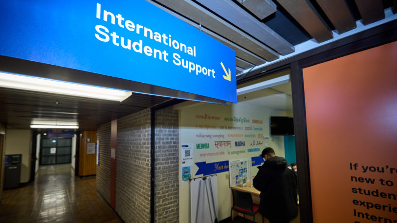 Sign pointing to the international student support office at TMU