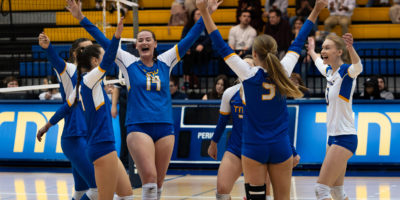 Members of the TMU Bold women's volleyball team celebrate after winning