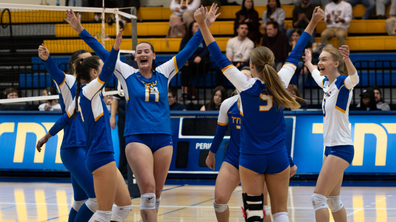 Members of the TMU Bold women's volleyball team celebrate after winning