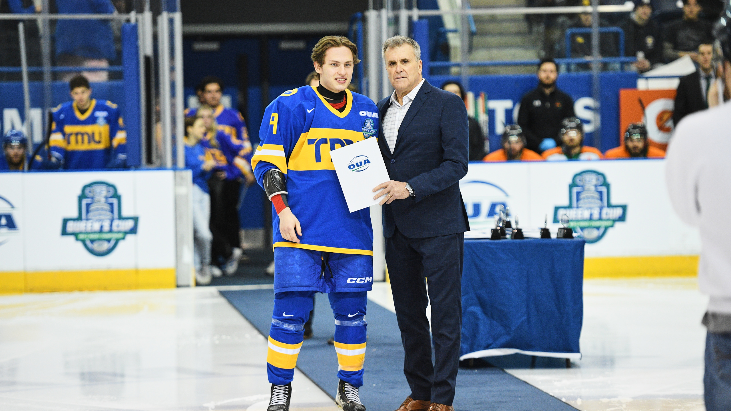TMU men's hockey player Daniil Grigorev accepts an award