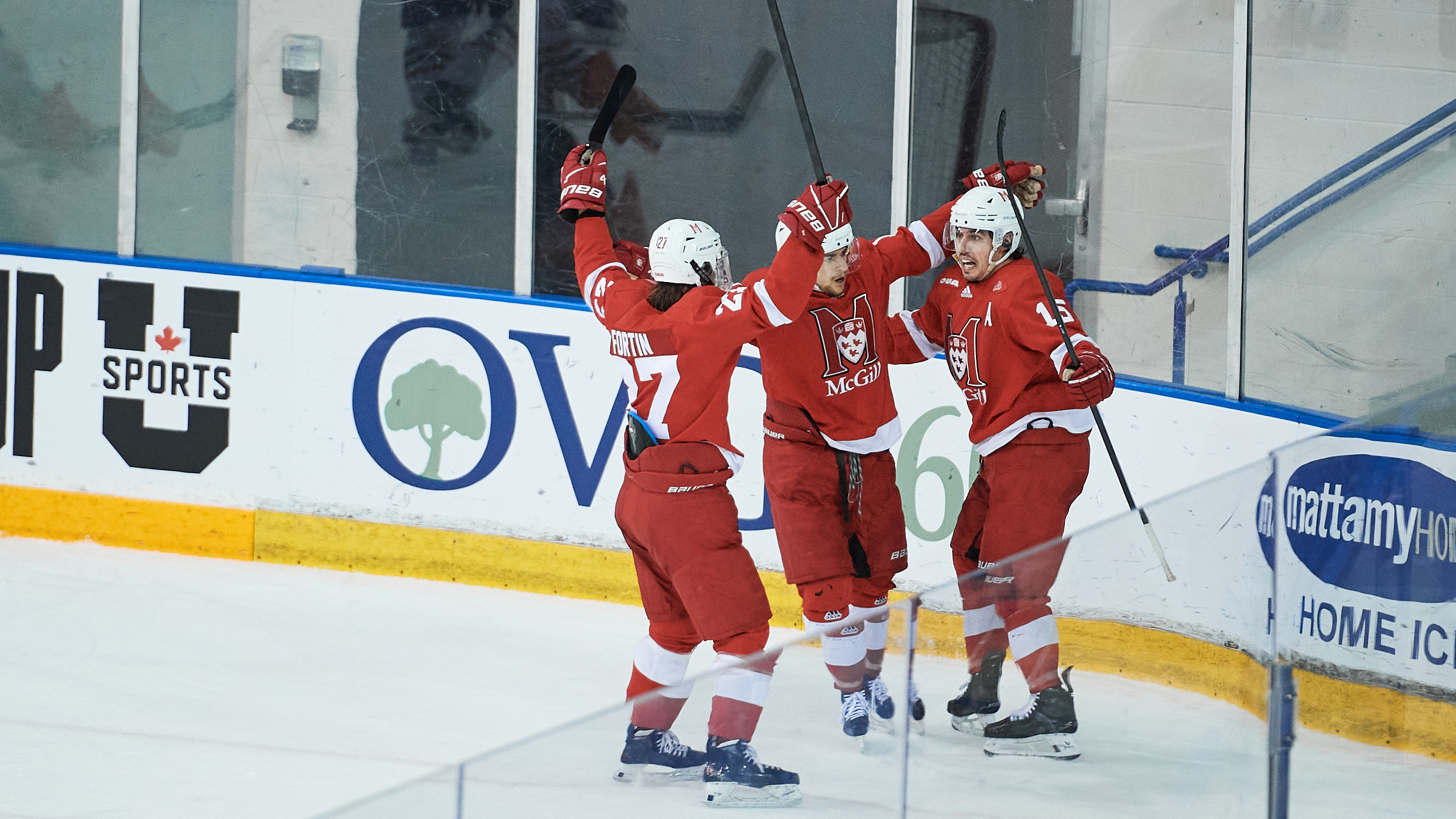McGill University hockey players celebrate with their hands in the air