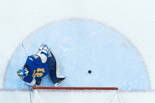 An overhead shot of the puck sliding by the Moncton goaltender