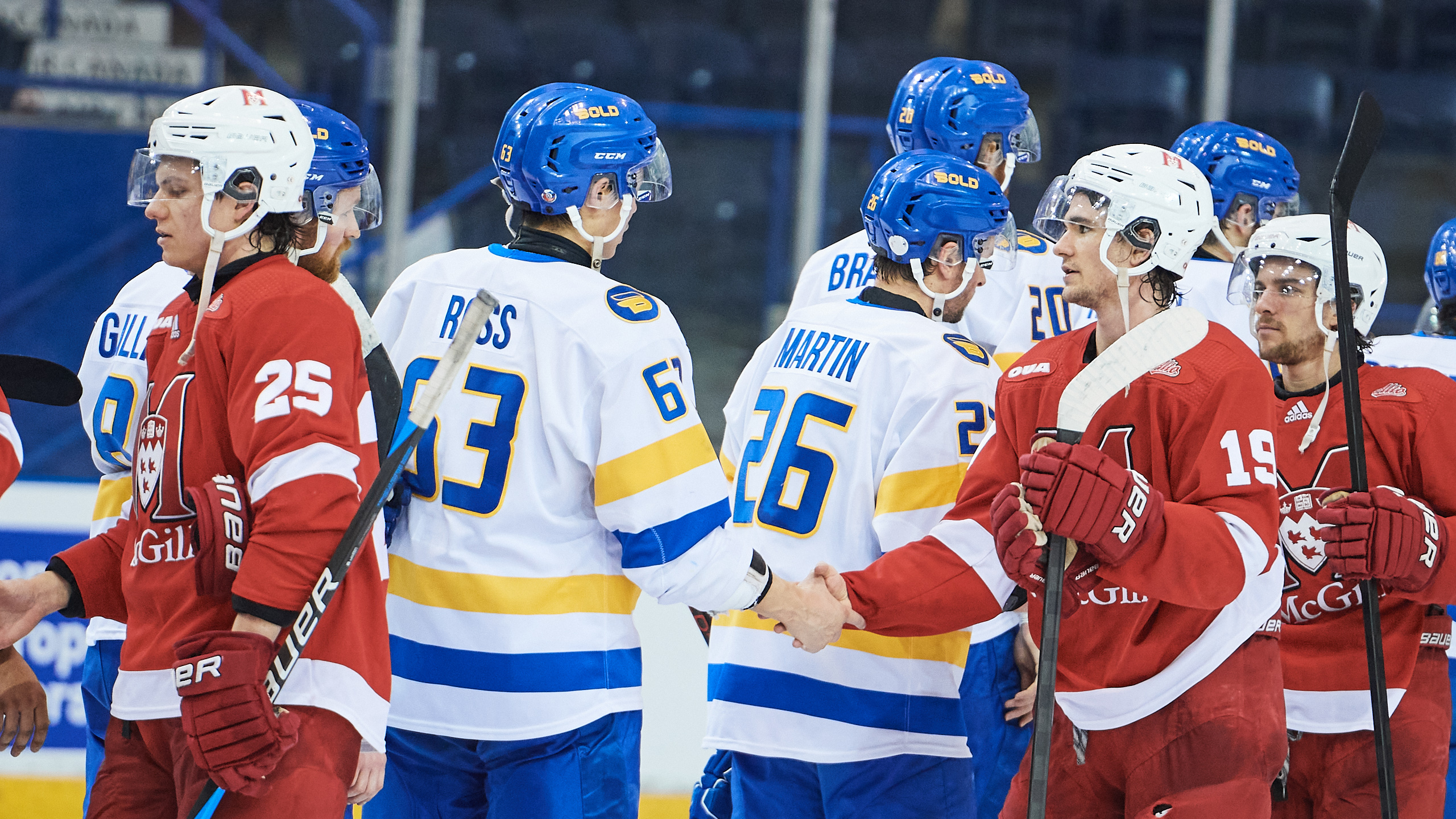 McGill and TMU players shake hands on the ice after the game