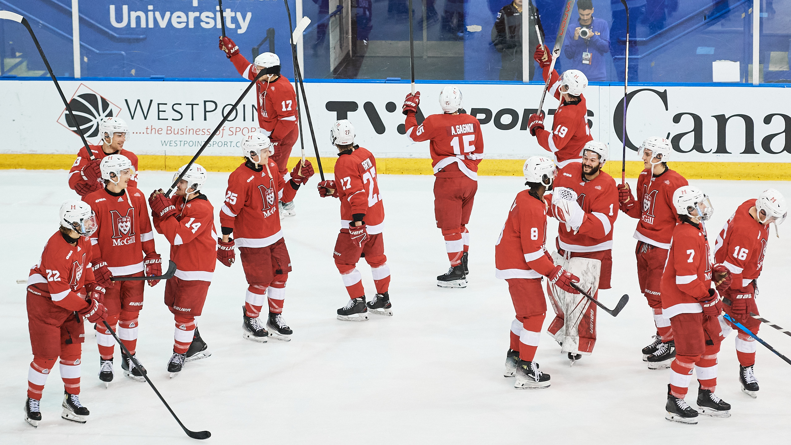 McGill hockey players raise their sticks in celebration of a win