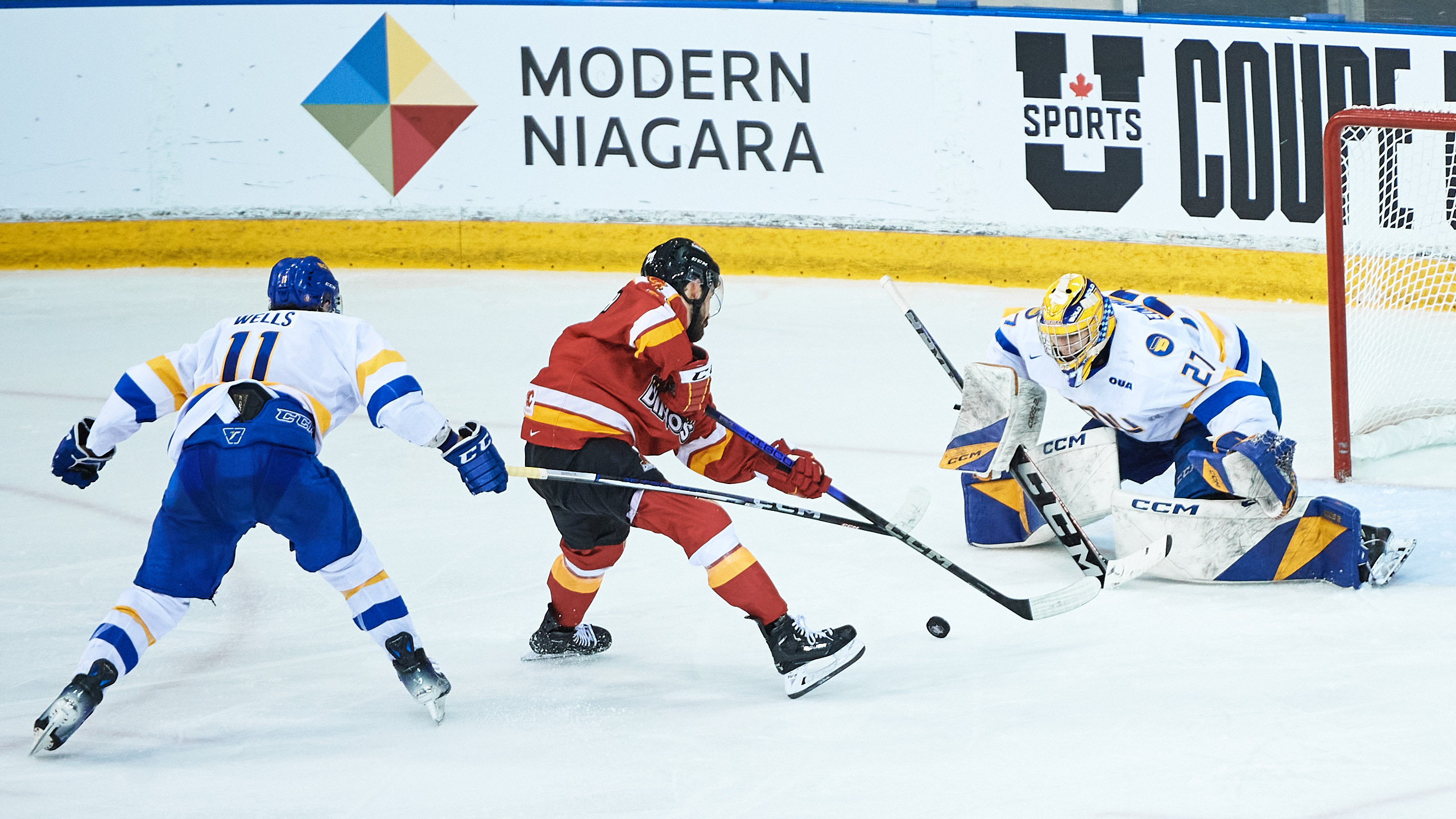 A Calgary player skates with the puck towards the TMU net