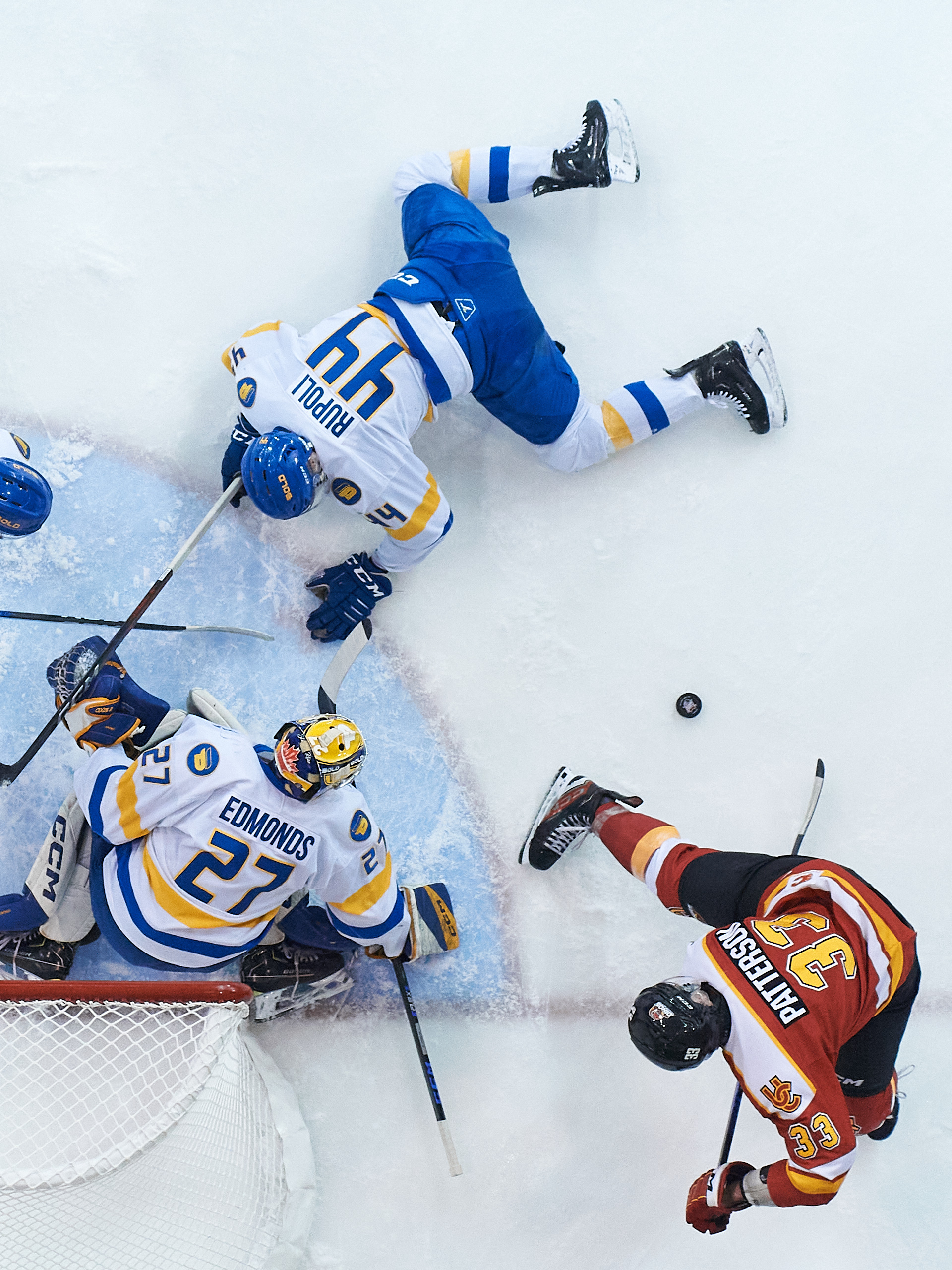 An overhead shot of the TMU net as a loose puck is between Calgary player and a sliding TMU player