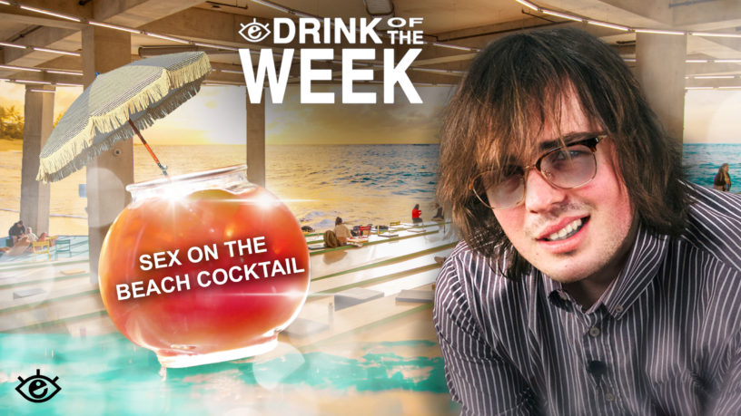 a man with sunglasses staring confused into the camera to the right, to the left a pink and red drink with an umbrella coming out of the top