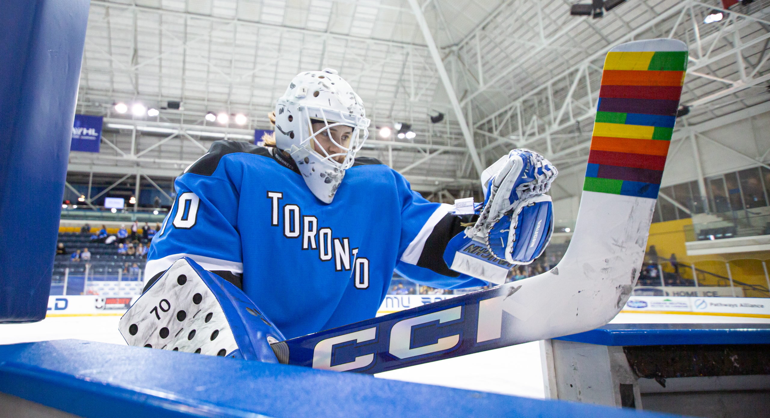 PWHL Toronto goaltender gets off the ice onto the bench with Pride Tape on the blade of her stick