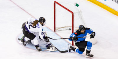 PWHL Toronto's Natalie Spooner skates away from the net after scoring against PWHL Minnesota goaltender Maddie Rooney, who is colliding with her defender. The puck is in the back of the net