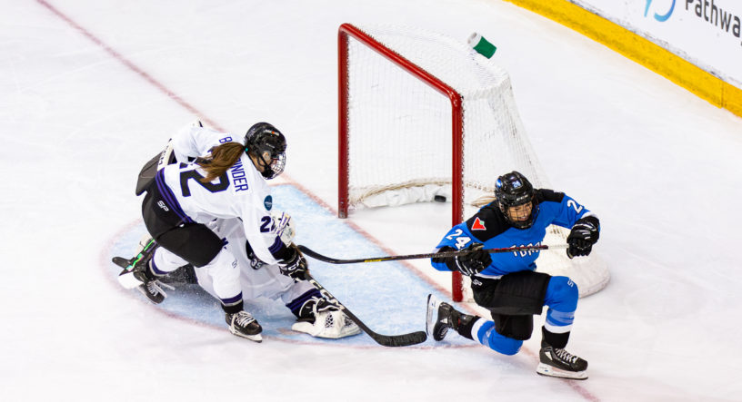 PWHL Toronto's Natalie Spooner skates away from the net after scoring against PWHL Minnesota goaltender Maddie Rooney, who is colliding with her defender. The puck is in the back of the net