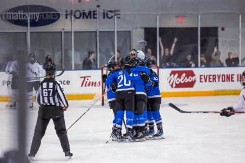 PWHL Toronto players group hug after a goal