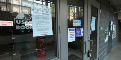 outside photo of a closed printing business with signs attached to the glass