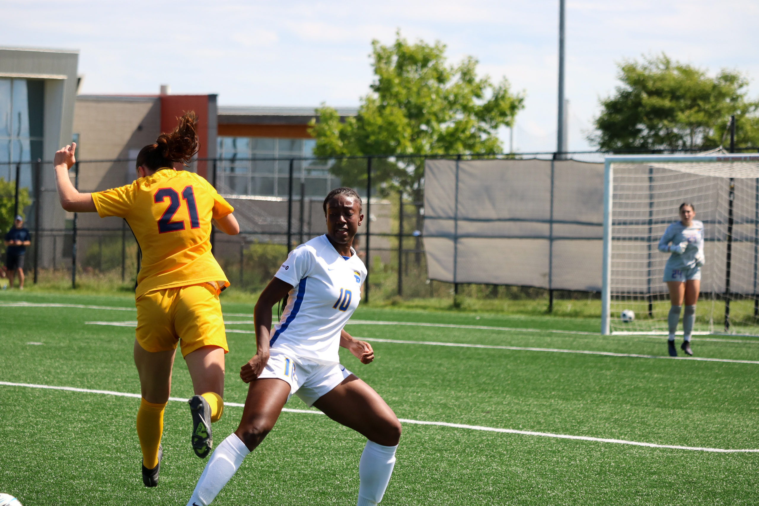 TMU player Tierra Bennett steps into a Queen's player in a number 21 jersey.