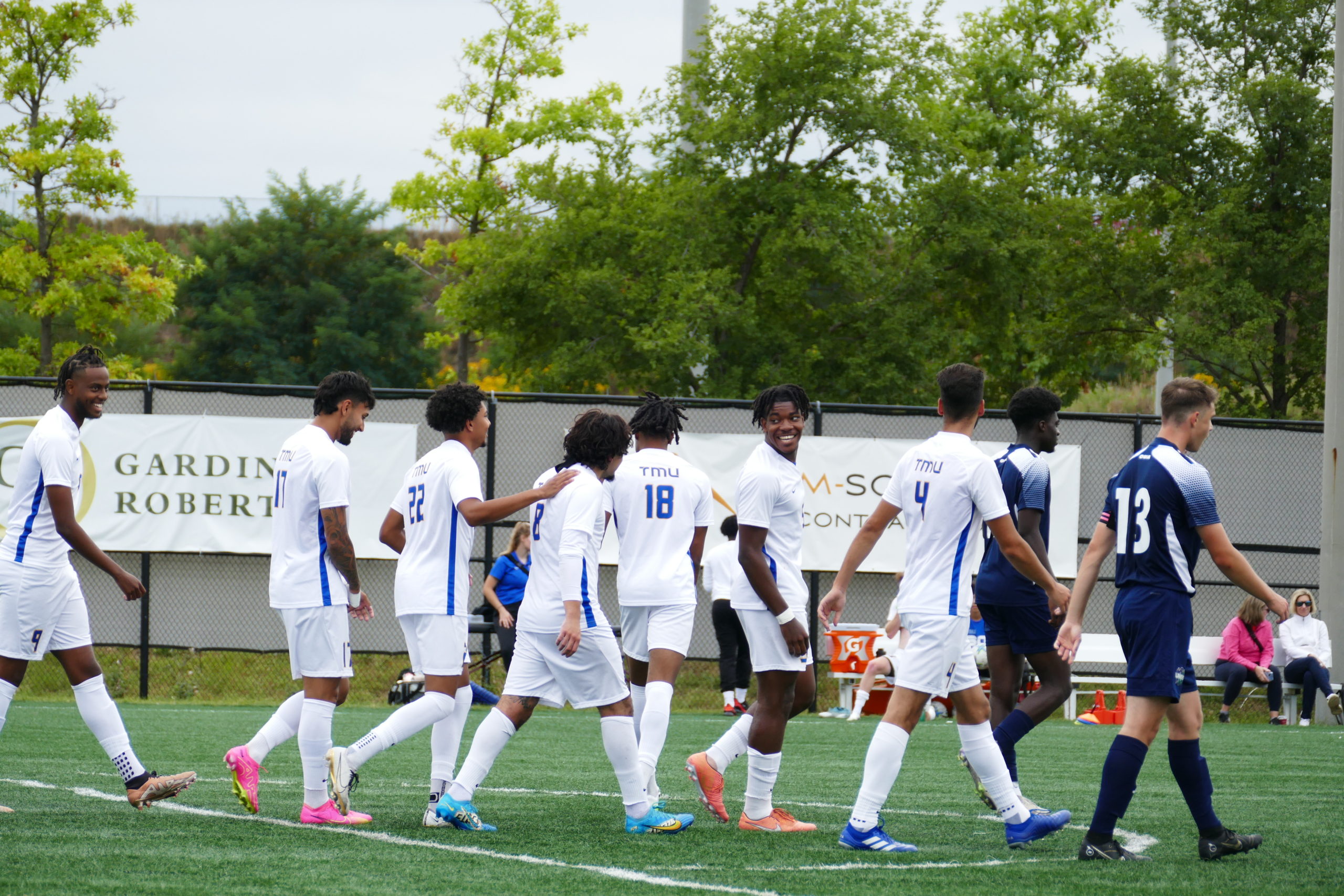 A soccer team walks across a field