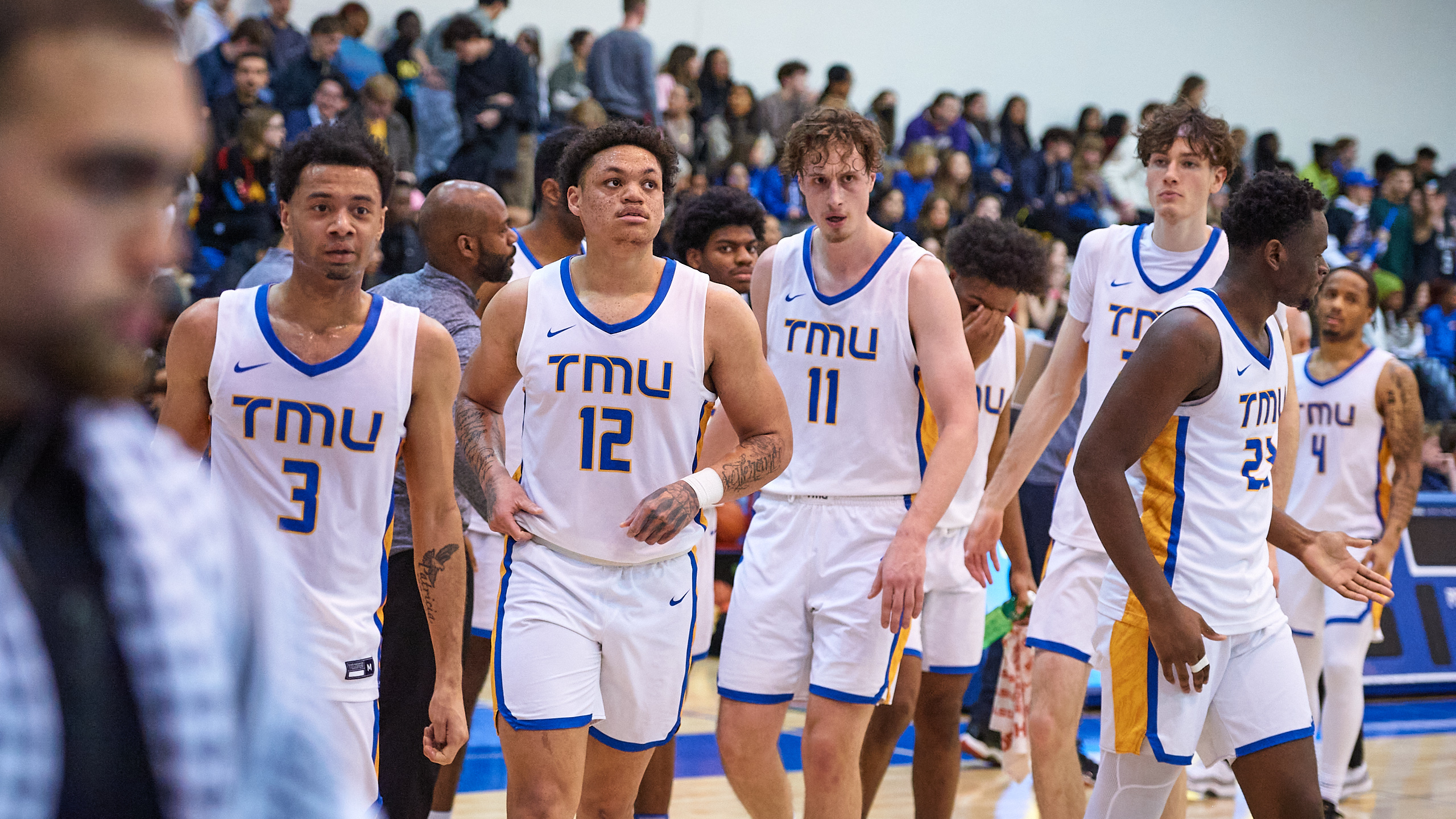 A male basketball team approaches the court