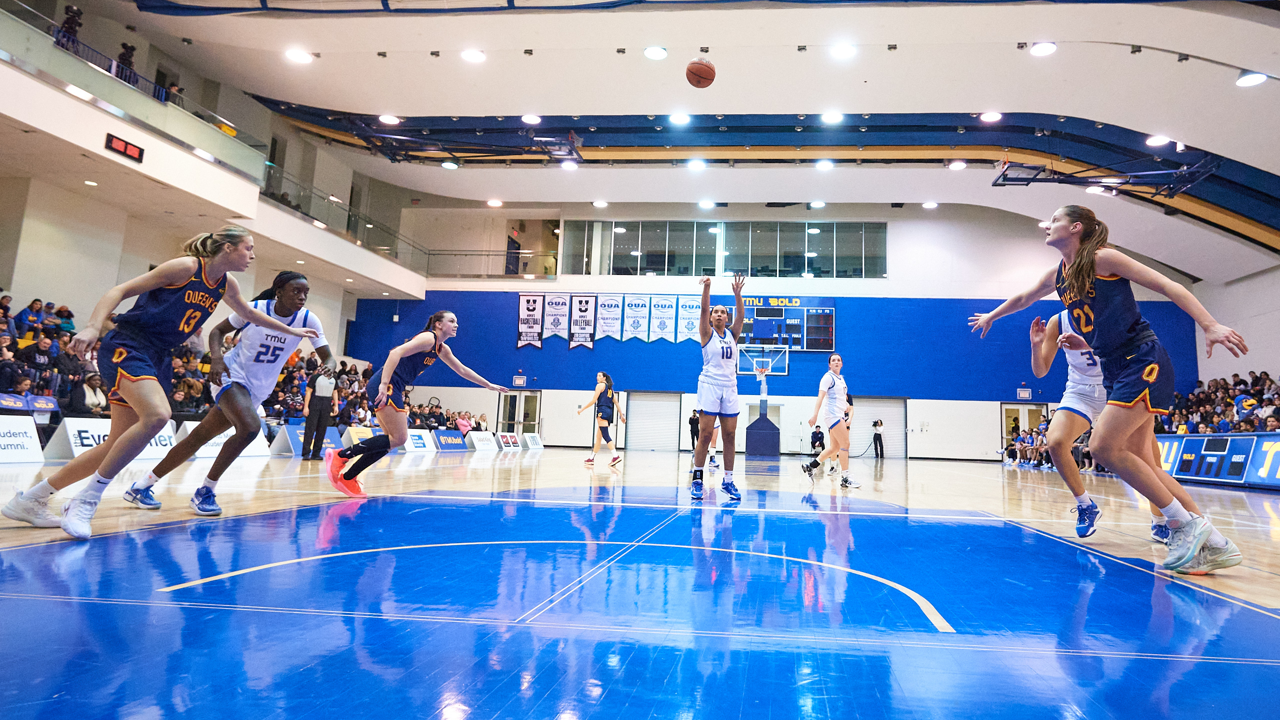 A volleyball game begins in a university gymnasium