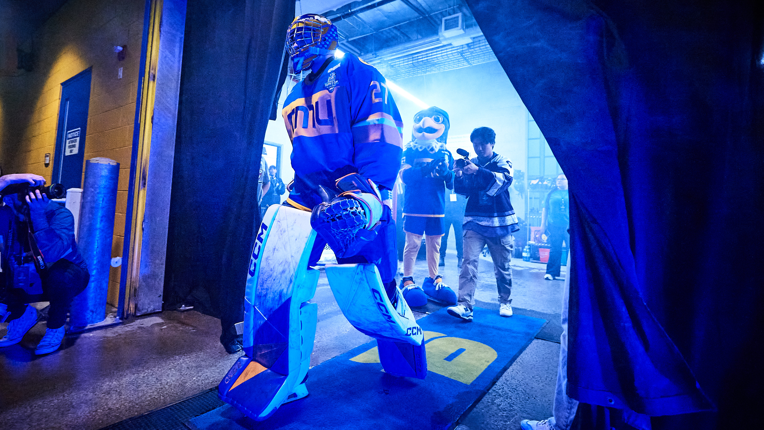 A hockey player dramatically enters the area with a camera behind him