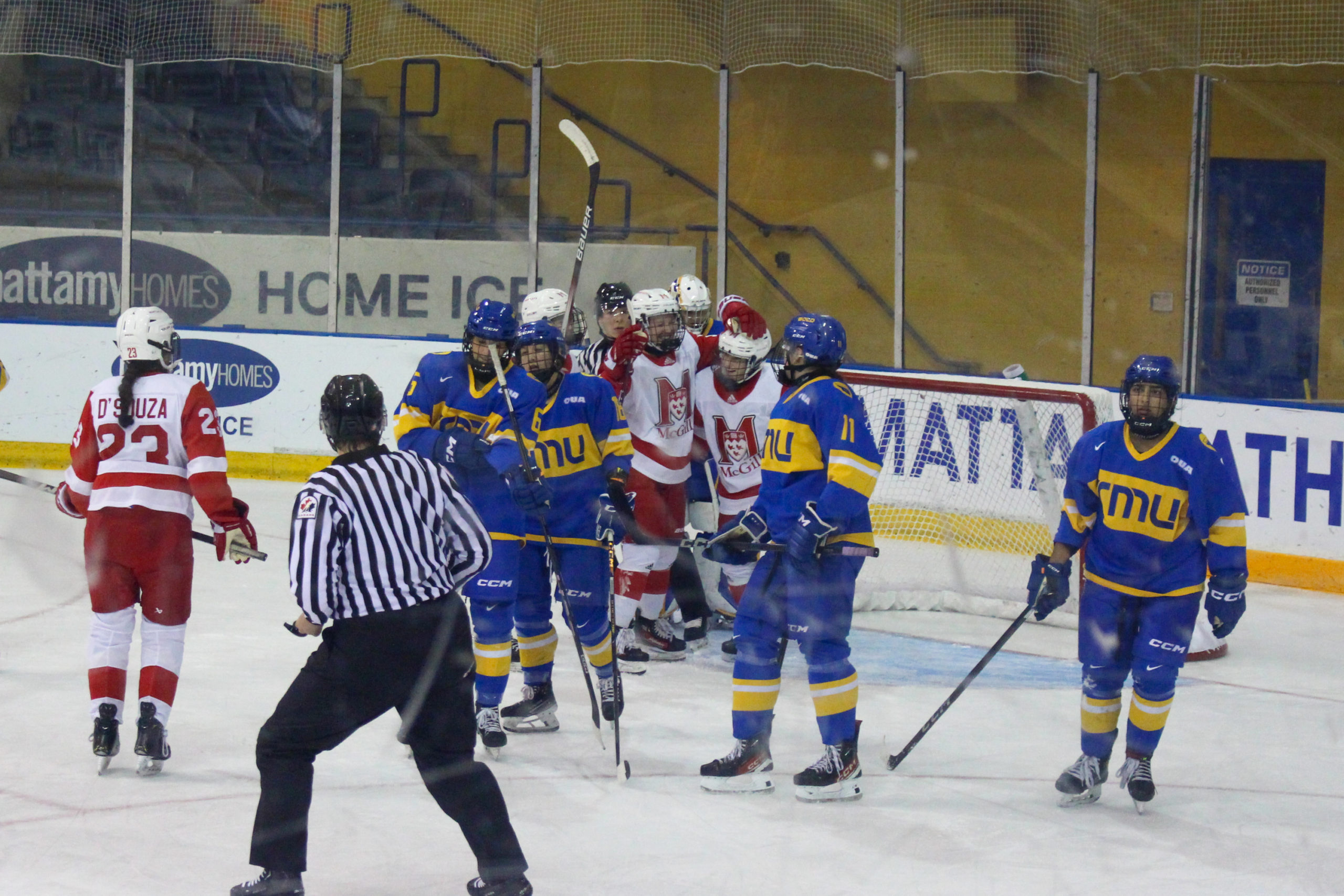 McGill Martlets players group hug as TMU players head back to their bench