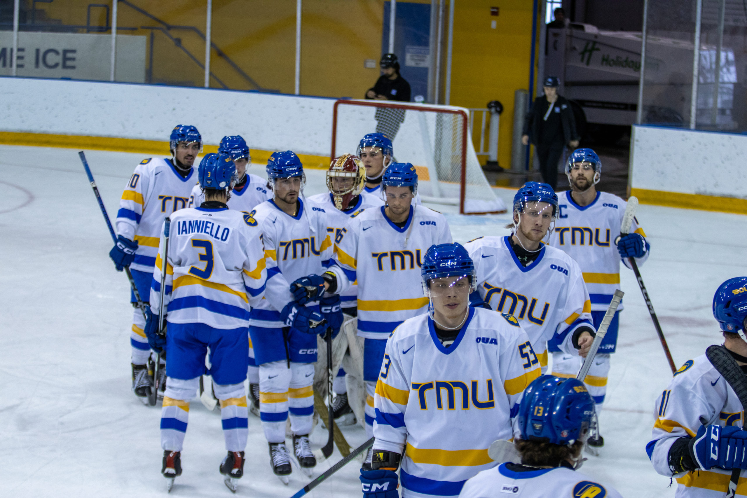 TMU Bold men's hockey players gather and give pats on the back after a game