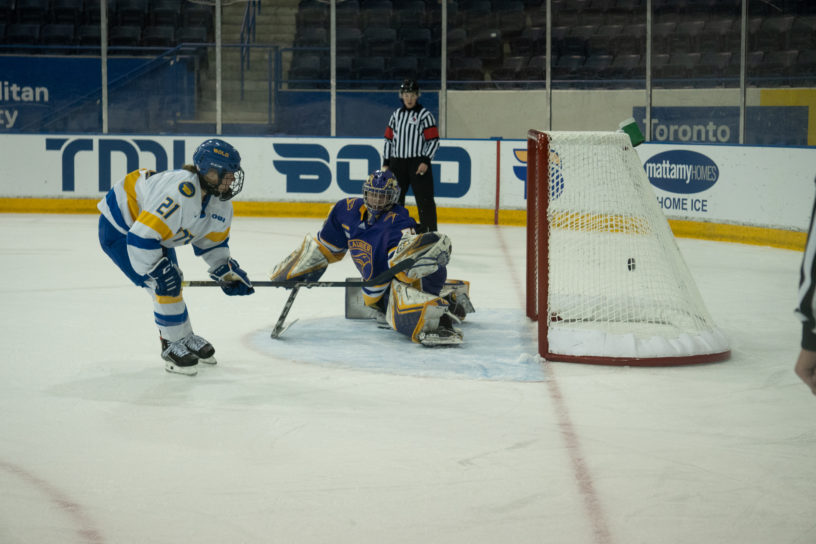 TMU Bold women's hockey player Emily Baxter backhands a shot past Laurier goaltender Kayla Renaud in the shootout