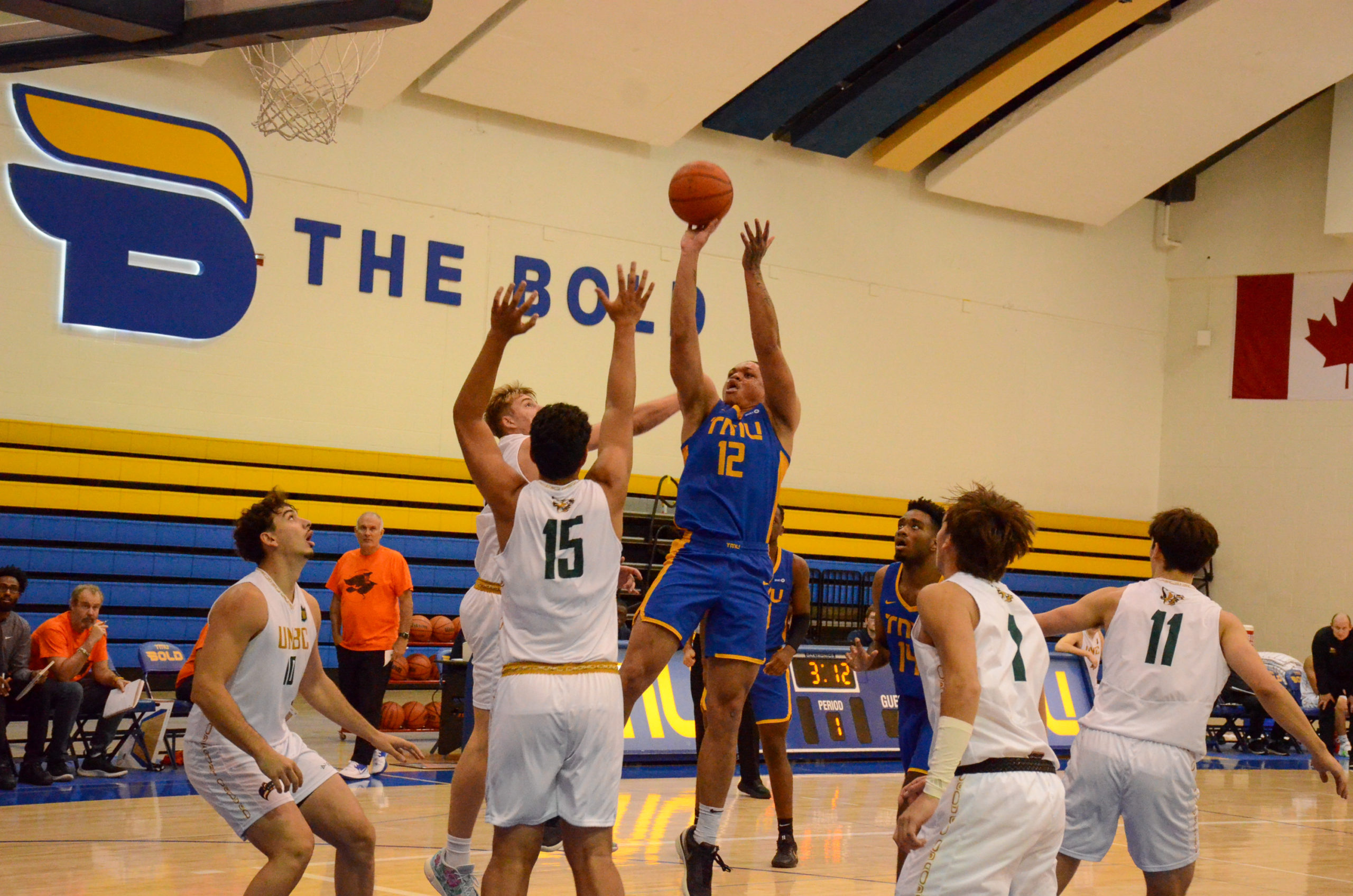 Aaron Rhooms shoots over multiple UNBC defenders