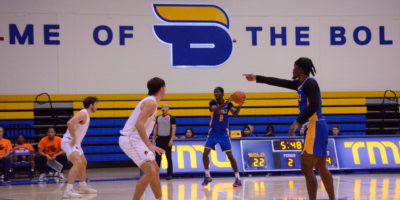 Javier Glasgow points as Thomasi Gilgeous-Alexander handles the ball. The words "Home of the Bold" with a B logo can be seen on the wall behind