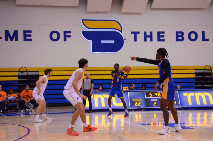 Javier Glasgow points as Thomasi Gilgeous-Alexander handles the ball. The words "Home of the Bold" with a B logo can be seen on the wall behind