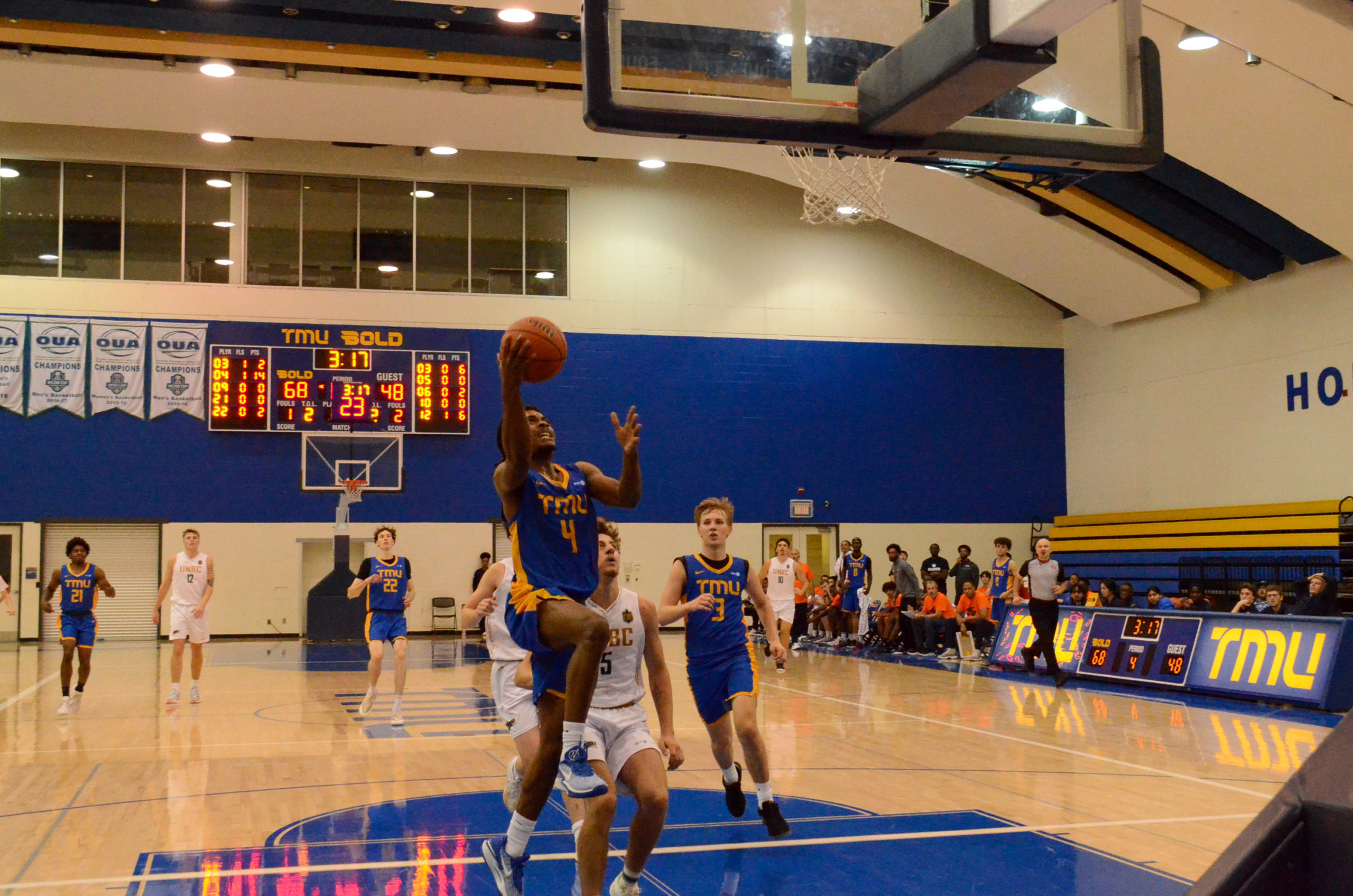 Maxine Louis-Jean shoots a lay-up with his right hand as opponents chase him down