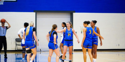 TMU Bold players congratulate Kaillie Hall with high fives after a basket