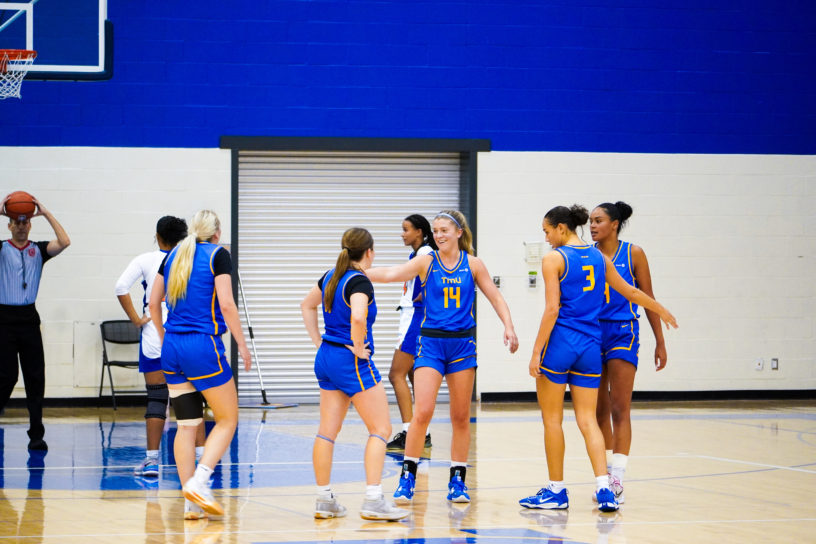 TMU Bold players congratulate Kaillie Hall with high fives after a basket