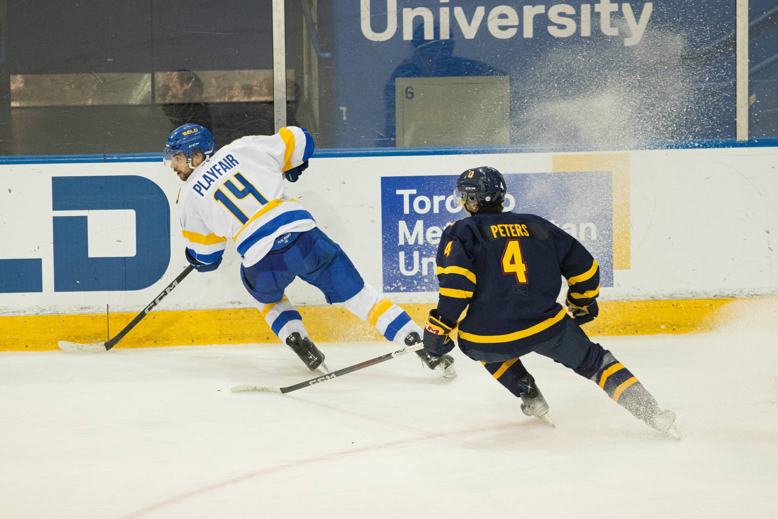 A TMU and a Queens player breaking with their skates